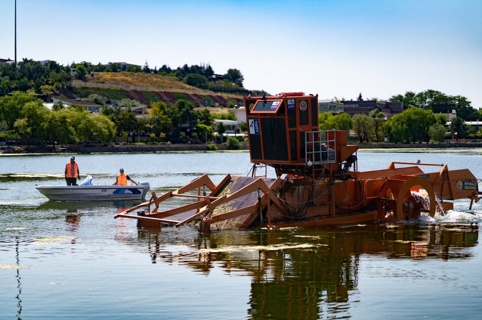 The team from Gölbaşı Municipality and Ankara Metropolitan Municipality work on cleaning Mogan Lake, Ankara, Türkiye, Aug. 6, 2024. (IHA Photo)