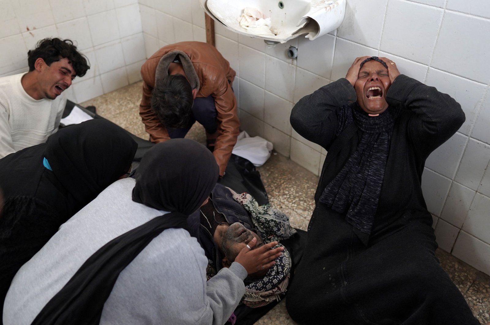 Relatives mourn over the dead body of a Palestinian man killed in Israeli airstrikes at the Al-Aqsa Martyrs Hospital in Deir al-Balah, central Gaza Strip, March 28, 2024. (AFP Photo)