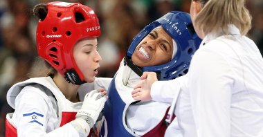Israel's Abishag Semberg (L) and Saudi Arabia's Dunya Ali M Abutaleb (C) compete in the taekwondo women's flyweight round of 16 bout of the Paris 2024 Olympic Games at the Grand Palais, Paris, France, Aug. 7, 2024. (AFP Photo)