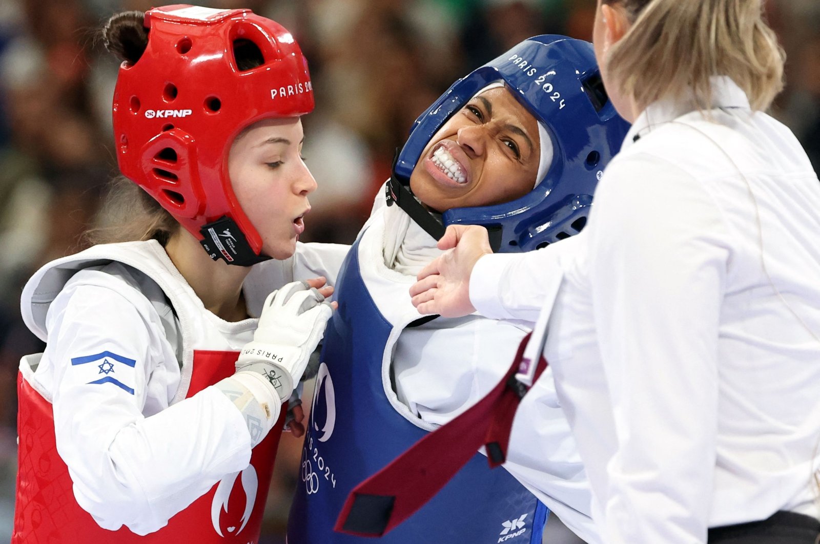 Israel&#039;s Abishag Semberg (L) and Saudi Arabia&#039;s Dunya Ali M Abutaleb (C) compete in the taekwondo women&#039;s flyweight round of 16 bout of the Paris 2024 Olympic Games at the Grand Palais, Paris, France, Aug. 7, 2024. (AFP Photo)