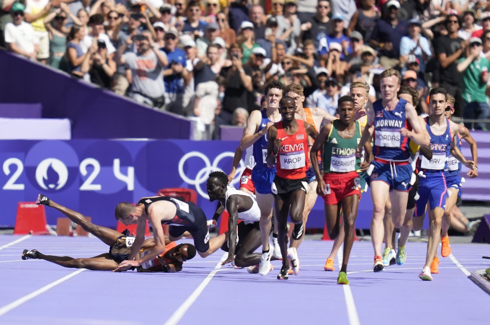 Runners fall in their heat of the men&#039;s 5000-meters at the 2024 Summer Olympics, Saint-Denis, France, Aug. 7, 2024. (AP Photo)