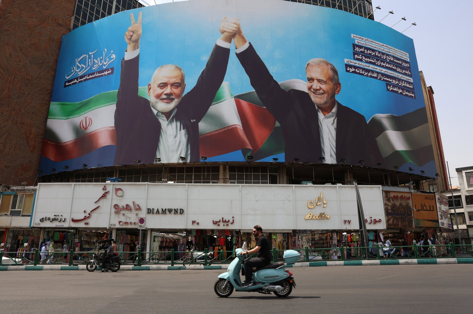  Iranians drive past a billboard depicting Iranian President Masoudd Pezeshkian (R) and Hamas late political leader Ismail Haniyeh, at Valiasr Square in Tehran, Iran, Aug. 1, 2024. (EPA Photo)