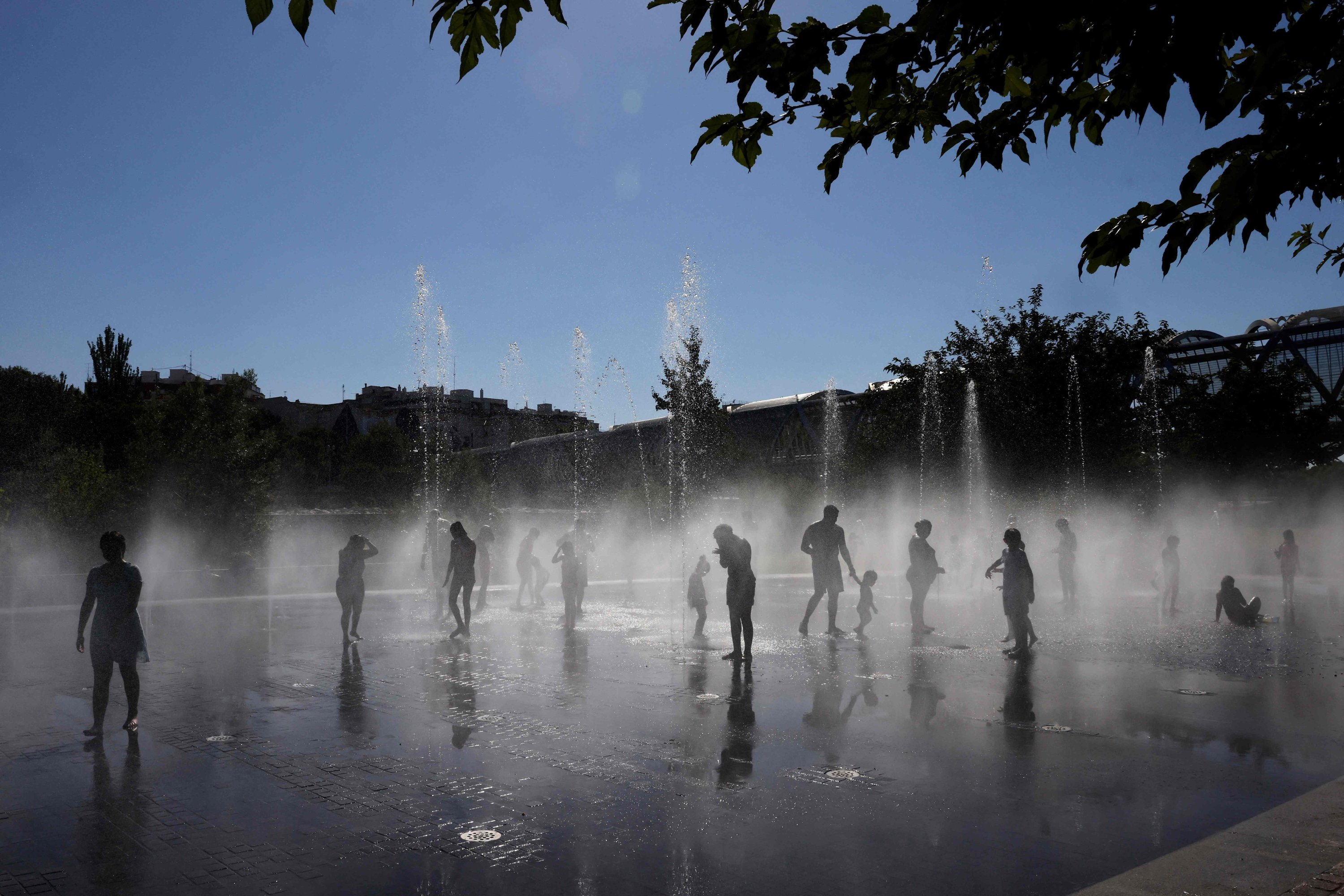 People cool off at a fountain in the Madrid Rio park amid heat wave conditions, Madrid, Spain, July 23, 2024. (AFP Photo)