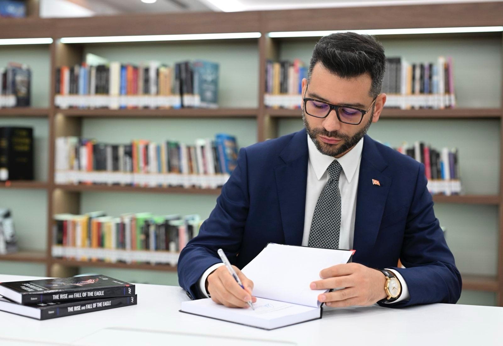 Associate professor Çağatay Özdemir signs his book in the capital Ankara, Türkiye, Aug. 8, 2024. (AA Photo)