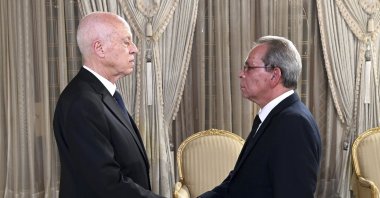 Tunisian President Kais Saied (L) shaking hands Prime Minister Ahmed Hachani, in Tunis, Tunisia, Aug. 1, 2023. (AP Photo)