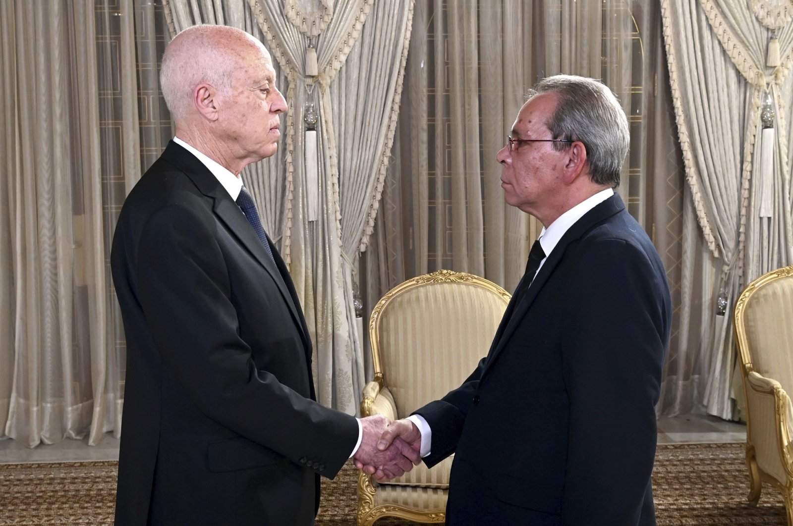 Tunisian President Kais Saied (L) shaking hands Prime Minister Ahmed Hachani, in Tunis, Tunisia, Aug. 1, 2023. (AP Photo)