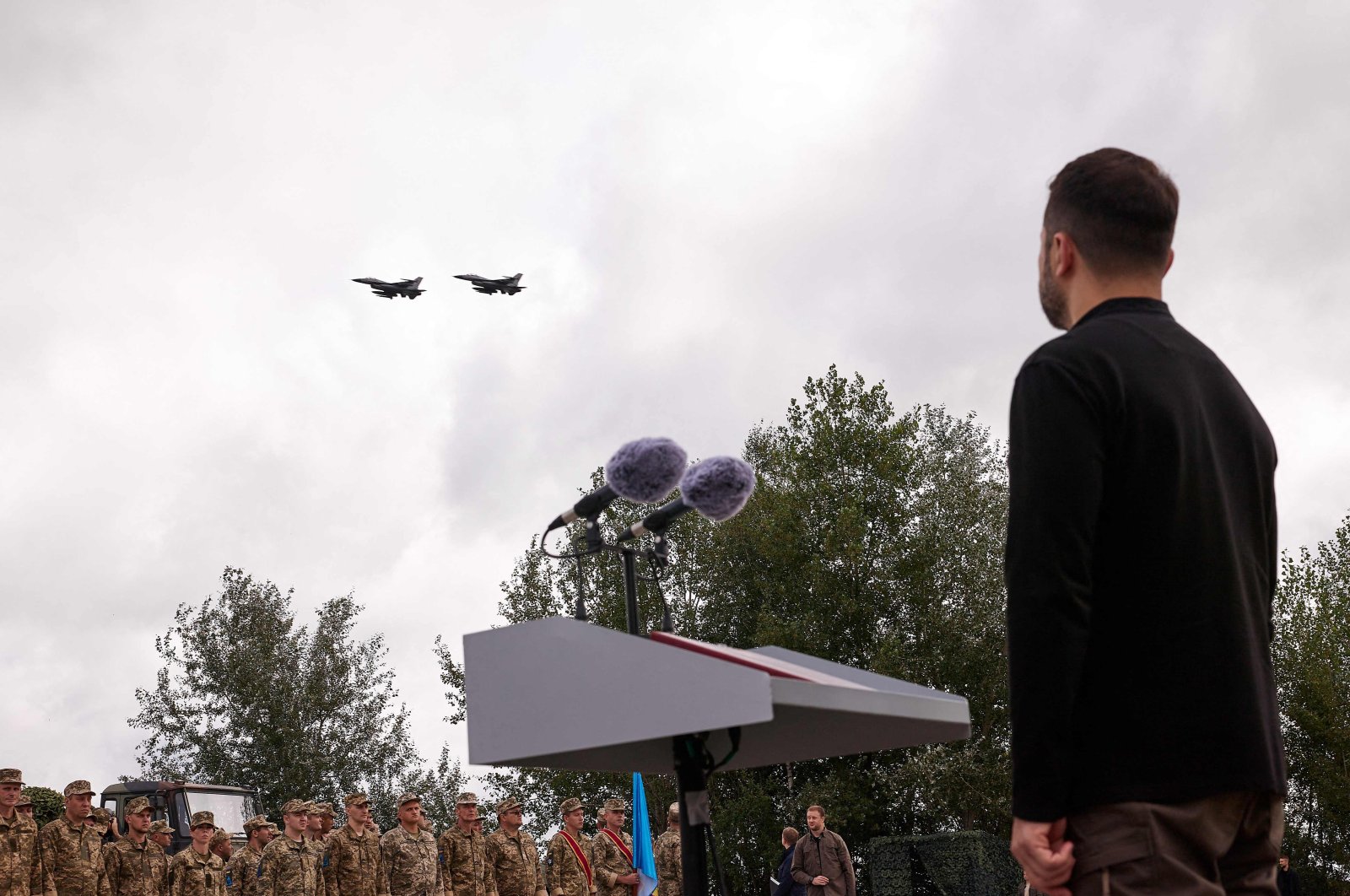 Ukrainian President Volodymyr Zelenskyy watches a pair of F-16 jets fly over during Ukraine's Air Force Day celebrations at an undisclosed location, amid the Russian invasion of Ukraine, Aug. 4, 2024. (AFP Photo)
