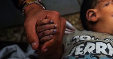 A man holding the hand of a boy killed in an Israeli bombardment mourns at the Al-Aqsa Martyrs Hospital, al-Nuseirat, Gaza Strip, Palestine, May 27, 2024. (AFP Photo)