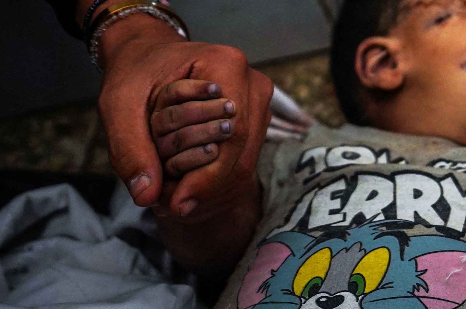 A man holding the hand of a boy killed in an Israeli bombardment mourns at the Al-Aqsa Martyrs Hospital, al-Nuseirat, Gaza Strip, Palestine, May 27, 2024. (AFP Photo)