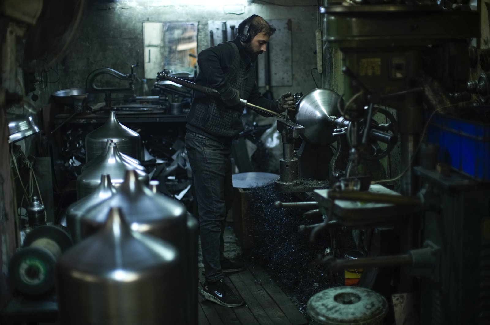 A worker shapes metal pieces for lamps in a workshop in Istanbul, Türkiye, Sept. 22, 2022. (AP Photo)