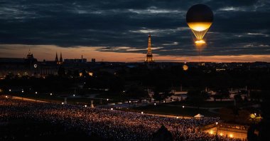 A crowd points their phones toward the cauldron of the Paris 2024 Olympic and Paralympic Games with the Eiffel Tower in the background, Paris, France, Aug. 8, 2024. (AFP Photo)