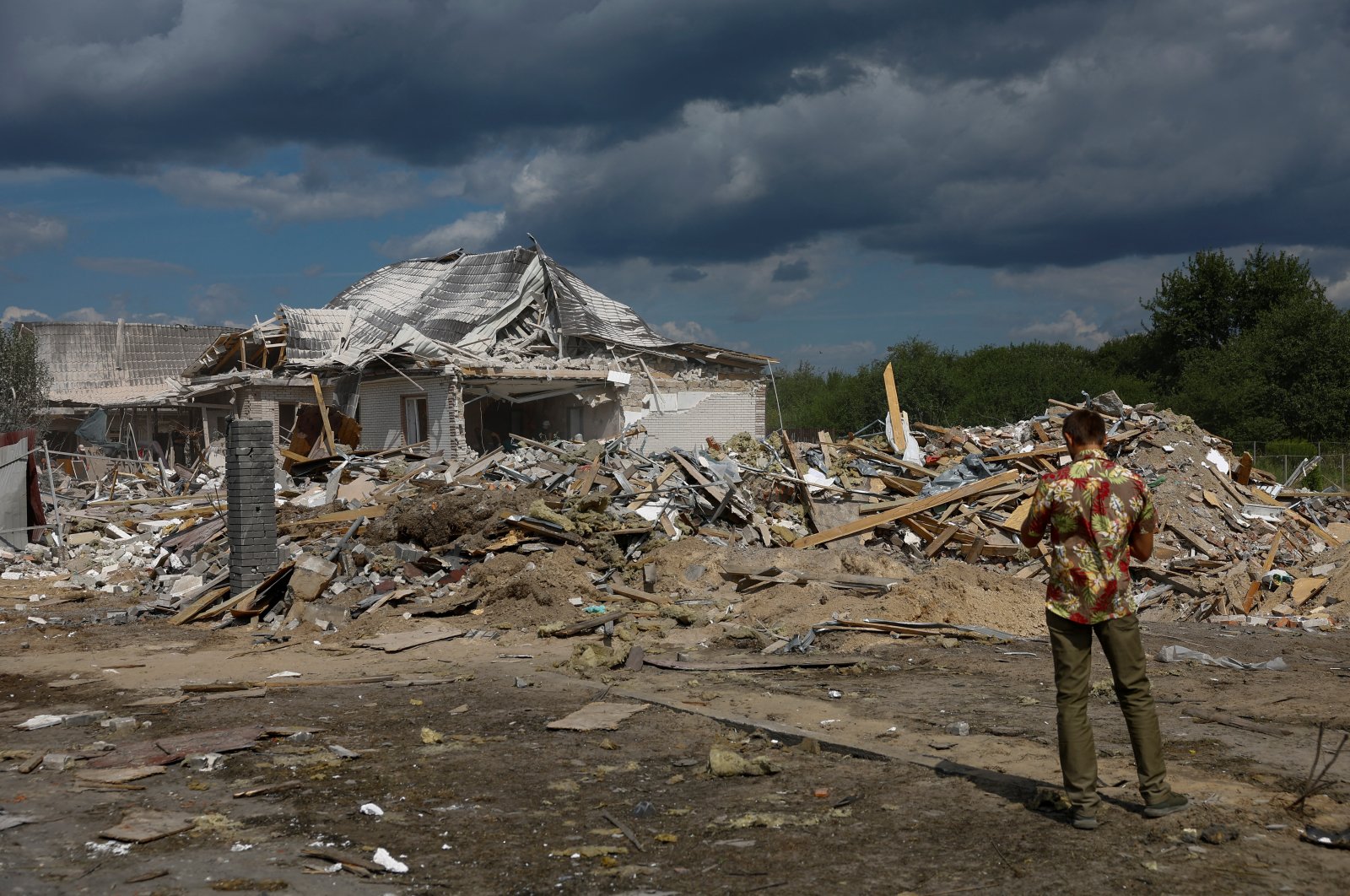 A man takes a picture of a residential building heavily damaged by a Russian missile strike, in the village of Rozhivka in Kyiv region, Ukraine, Aug. 11, 2024. (Reuters Photo)