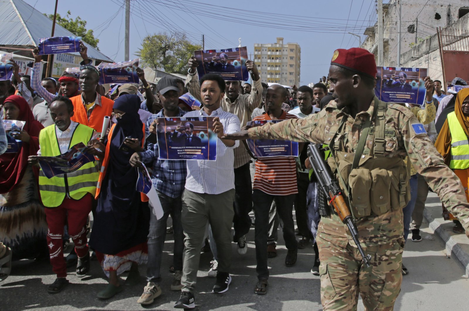 A Somali soldier controls the crowd as thousands of people attend a protest rally against a deal between Ethiopia and Somaliland, in Mogadishu, Somalia, Jan. 3, 2024. (AP Photo)