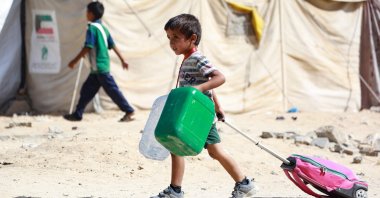 A Palestinian child drags along his bag as people flee the Hamad residential district in Khan Younis, southern Gaza Strip, Palestine, Aug. 11, 2024. (AFP Photo)