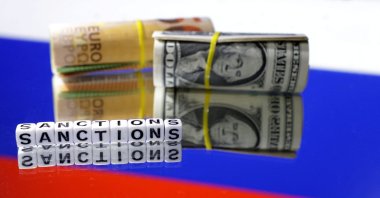 Euro and dollar banknotes and the words "Sanctions" are placed on the Russian flag in this illustration taken on May 16, 2024. (Reuters Photo)