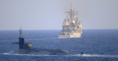 U.S. Navy guided-missile submarine USS Georgia escorts the guided-missile cruiser USS Port Royal through the Strait of Hormuz in the Persian Gulf, Dec. 21, 2020. (AP Photo)