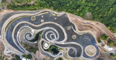 A drone view of a park transformed into a replica of Vincent Van Gogh's famous painting "The Starry Night," featuring fields of lavender, shrubs, and lakes connected by an array of paths, a project that mirrors the celebrated artwork in a natural setting, Visoko, Bosnia-Herzegovina, Aug. 3, 2024. (Reuters Photo)