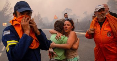 Women embrace after being rescued during a wildfire in Varnavas, north of Athens, Aug. 11, 2024. (AFP Photo)