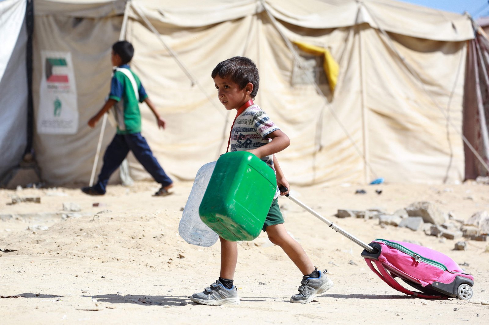 A Palestinian child drags along his bag as people flee the Hamad residential district in Khan Younis, southern Gaza Strip, Palestine, Aug. 11, 2024. (AFP Photo)