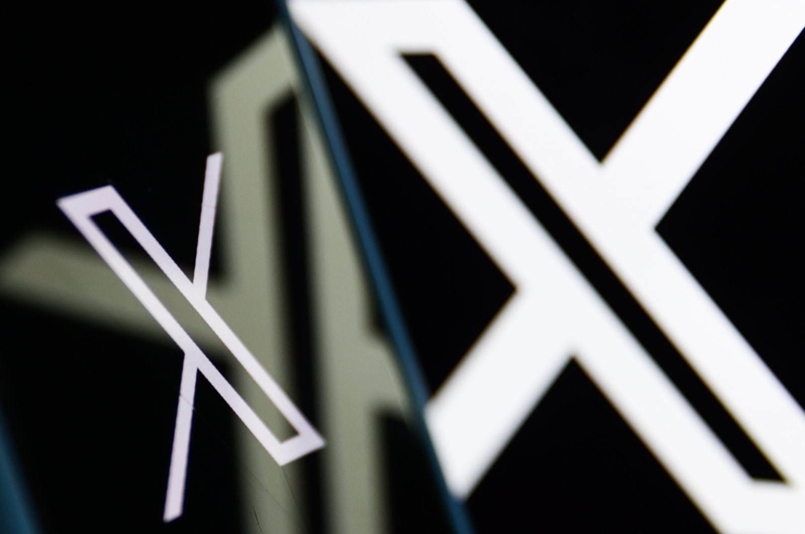 The X logo displayed on a phone screen and a laptop screen is seen in this illustration photo taken in Poland, July 24, 2024. (Reuters Photo)