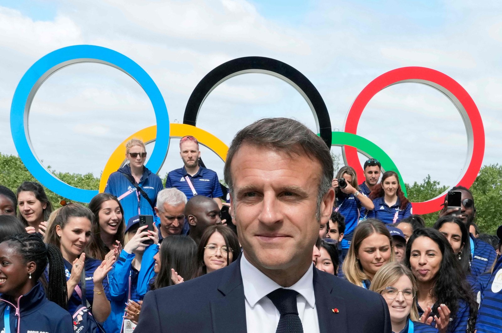 French President Emmanuel Macron looks on with the Olympic rings and French athletes behind him, Paris, U.S., July 22, 2024. (AFP Photo)