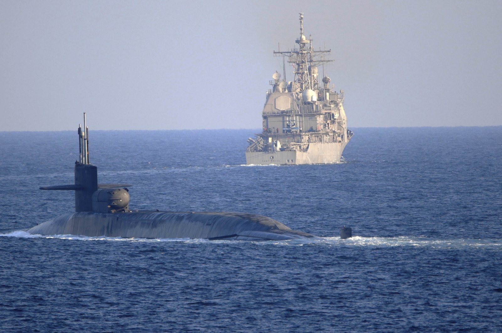 U.S. Navy guided-missile submarine USS Georgia escorts the guided-missile cruiser USS Port Royal through the Strait of Hormuz in the Persian Gulf, Dec. 21, 2020. (AP Photo)