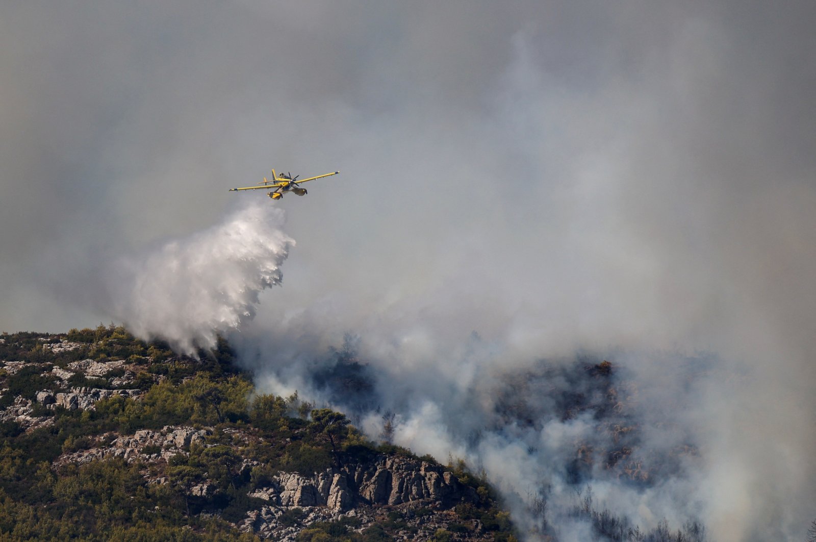 A firefighting plane makes a water drop as a wildfire burns in Grammatiko, near Athens, Greece, Aug. 12, 2024. (Reuters Photo)