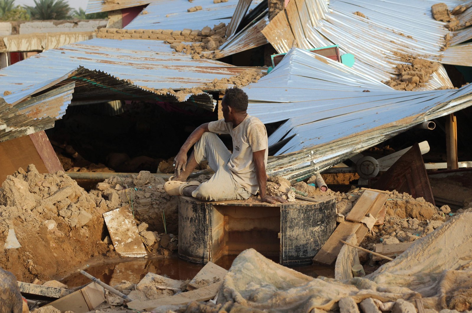 A Sudanese man sits amid the destruction in his village near the town of Dongola, northern Sudan, Aug. 11, 2024. (AFP Photo)