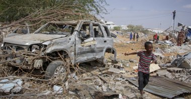 A young boy runs past the wreckage of a vehicle destroyed in an attack by al-Shabab on police and checkpoints on the outskirts of the capital of Mogadishu, Somalia, Feb. 16, 2022. (AP Photo)