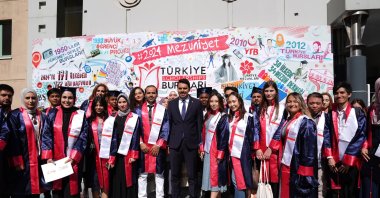 YTB President Abdullah Eren (C) and graduates pose for a photo at the graduation ceremony, Istanbul, Türkiye, Aug. 12, 2024. (AA Photo)