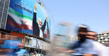 Iranians drive past next to a huge billboard of late Hamas leader Ismail Haniyeh on a street in Tehran, Iran, Aug. 13, 2024. (EPA Photo)