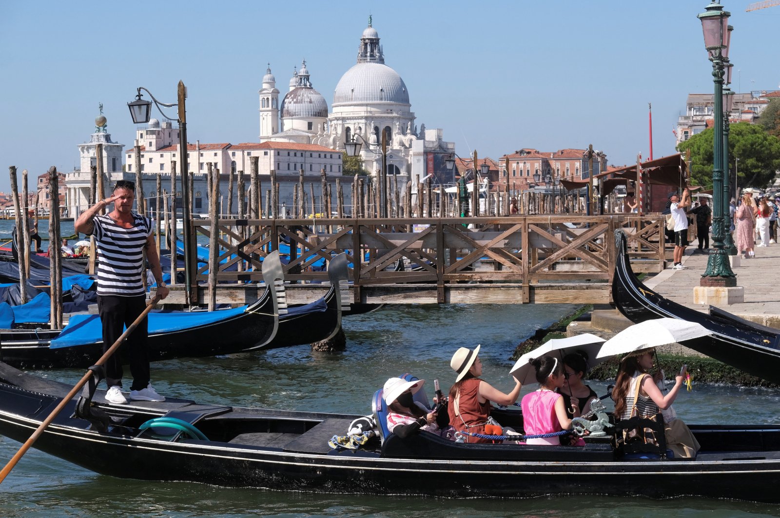 Tourists sail in a gondola with umbrellas as temperatures soar, Venice, Italy, Aug. 10, 2024. (Reuters Photo)