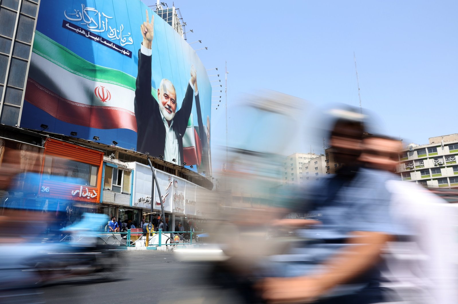 Iranians drive past next to a huge billboard of late Hamas leader Ismail Haniyeh on a street in Tehran, Iran, Aug. 13, 2024. (EPA Photo)