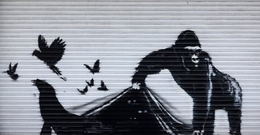 An artwork by street artist Banksy, the ninth to released in nine days, depicts a gorilla releasing animals, on the front of a shutter outside London Zoo, London, Britain, Aug. 13, 2024. (AFP Photo)