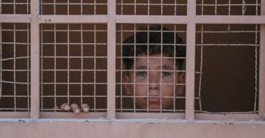 A Palestinian boy looks out from inside the Asdaa central prison facility which has become a shelter for displaced people, Khan Younis, southern Gaza, Palestine, Aug. 14, 2024. (AFP Photo)
