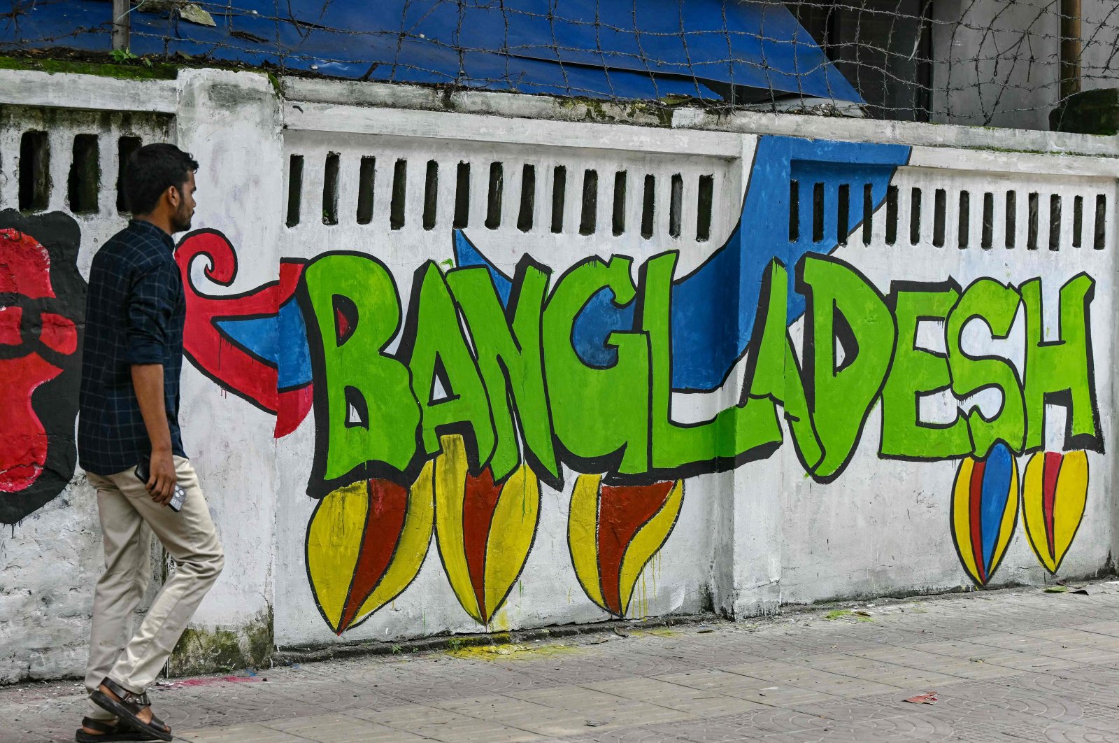 A pedestrian walks past a mural inside Dhaka University days after the fall of the Sheikh Hasina government, Dhaka, Bangladesh, Aug. 12, 2024. (AFP Photo)