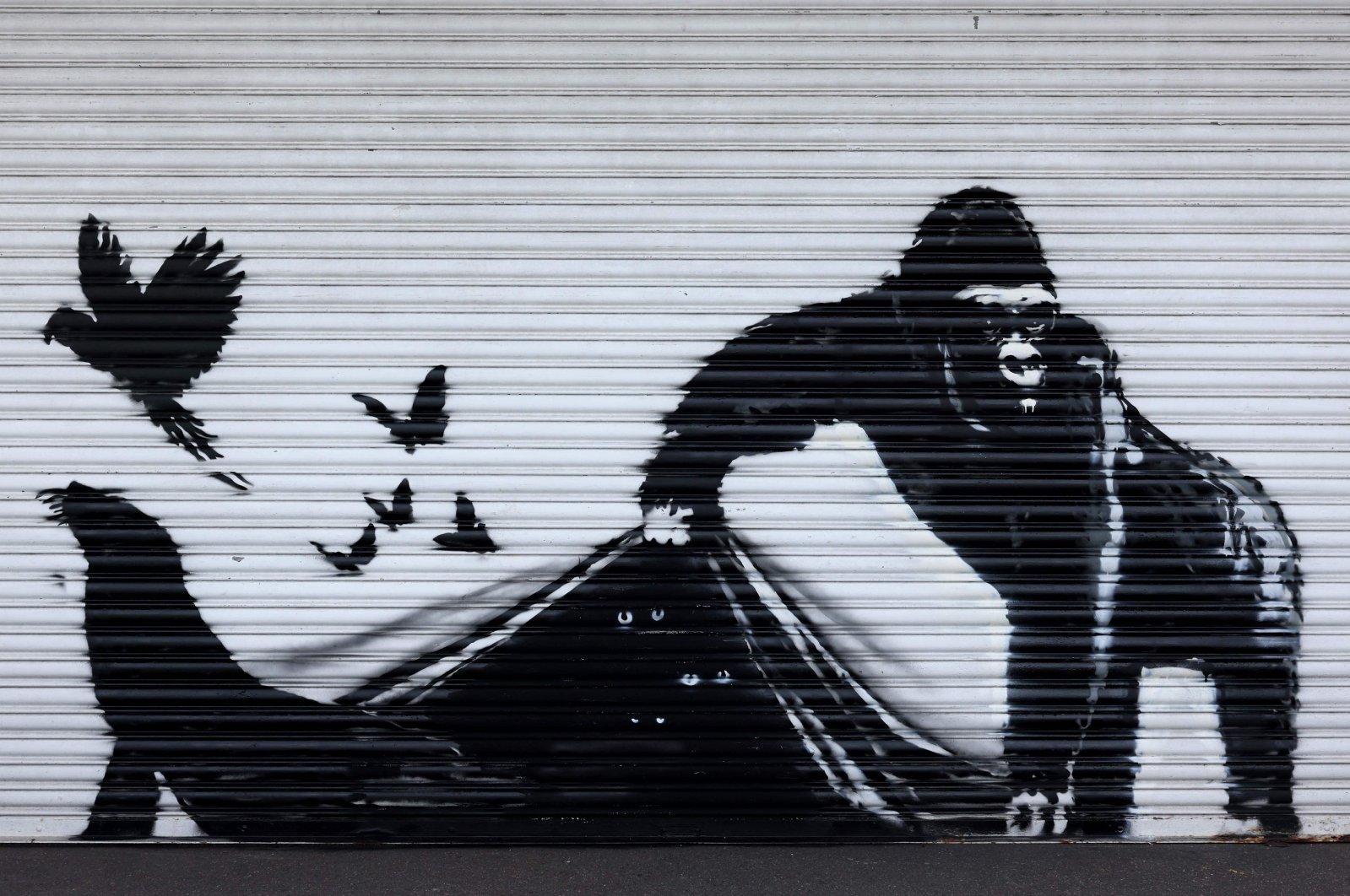 An artwork by street artist Banksy, the ninth to released in nine days, depicts a gorilla releasing animals, on the front of a shutter outside London Zoo, London, Britain, Aug. 13, 2024. (AFP Photo)