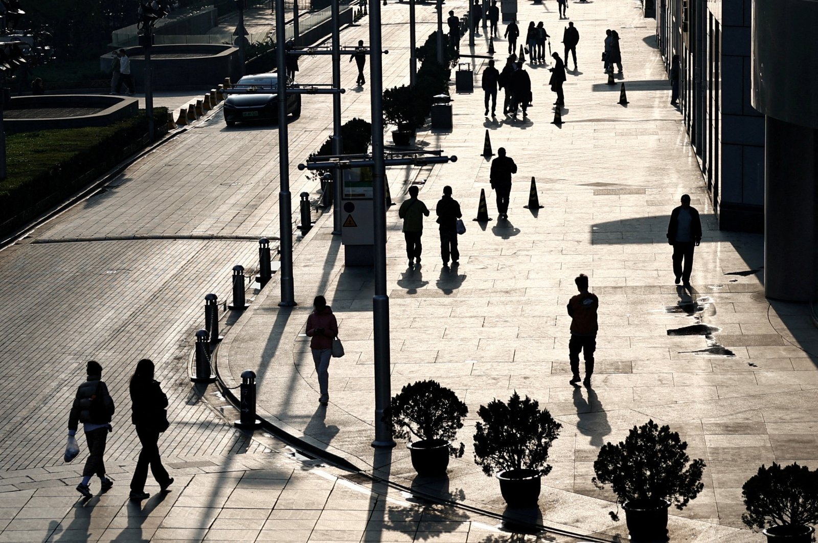 People walk past an office and shopping complex in Beijing, China, April 10, 2024. (Reuters Photo)