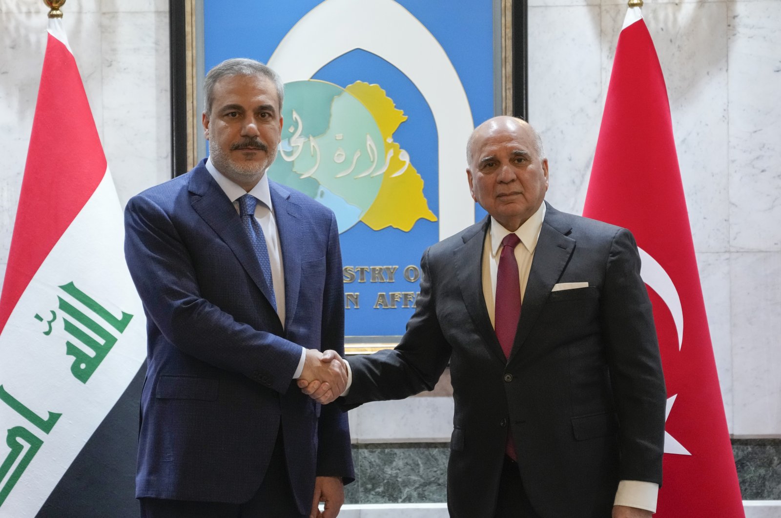 Iraqi Foreign Minister Fuad Hussein (R) shakes hands with visiting Foreign Minister Hakan Fidan (L), Baghdad, Iraq, March 14, 2024. (AP Photo)