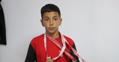 Turkish young wrestler Berat Çelik poses with his İsmail Demirci U13 Boys Freestyle Wrestling Championships medals, Ağrı, Türkiye, Aug. 15, 2024. (IHA Photo)