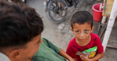 An injured Palestinian child holds food as he poses for a picture in Khan Younis, southern Gaza Strip, Palestine, Aug. 15, 2024. (AFP Photo)