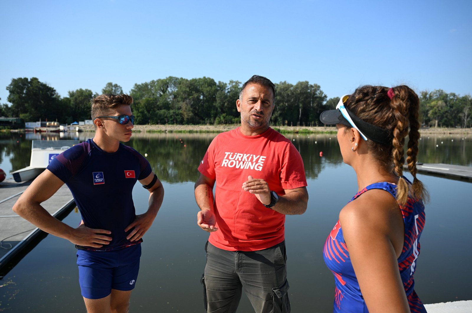 Turkish rowing national team Coach Orkun Pelvan (C) instructs rowers Yiğit Doğukan Bozkurt (L) and Nurşen Şen at the Meriç River, Edirne, Türkiye, Aug. 3, 2024. (AA Photo)