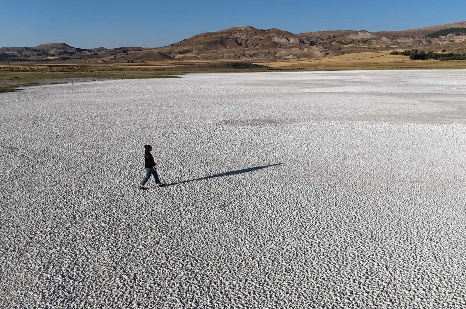 A local walks on the dried-up surface of Kellah Lake, Sivas, Türkiye, Aug. 15, 2024. (IHA Photo)