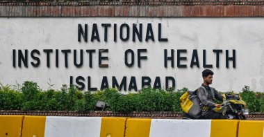 A delivery boy rides past the building of the National Institute of Health (NIH), a Pakistani research institute mainly responsible for biomedical and health-related research, Islamabad, Pakistan, Aug. 16, 2024. (AFP Photo)