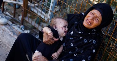 Reem Abu Haya, a Palestinian girl who survived an Israeli strike that killed her entire family, cries as she is held by a relative at Nasser Hospital, in Khan Younis in the southern Gaza Strip, Aug. 13, 2024. (Reuters Photo)