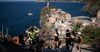 Tourists look out from a hillside in Vernazza in the Cinque Terre National Park, near La Spezia, Italy, Aug. 14, 2024. (AFP Photo)