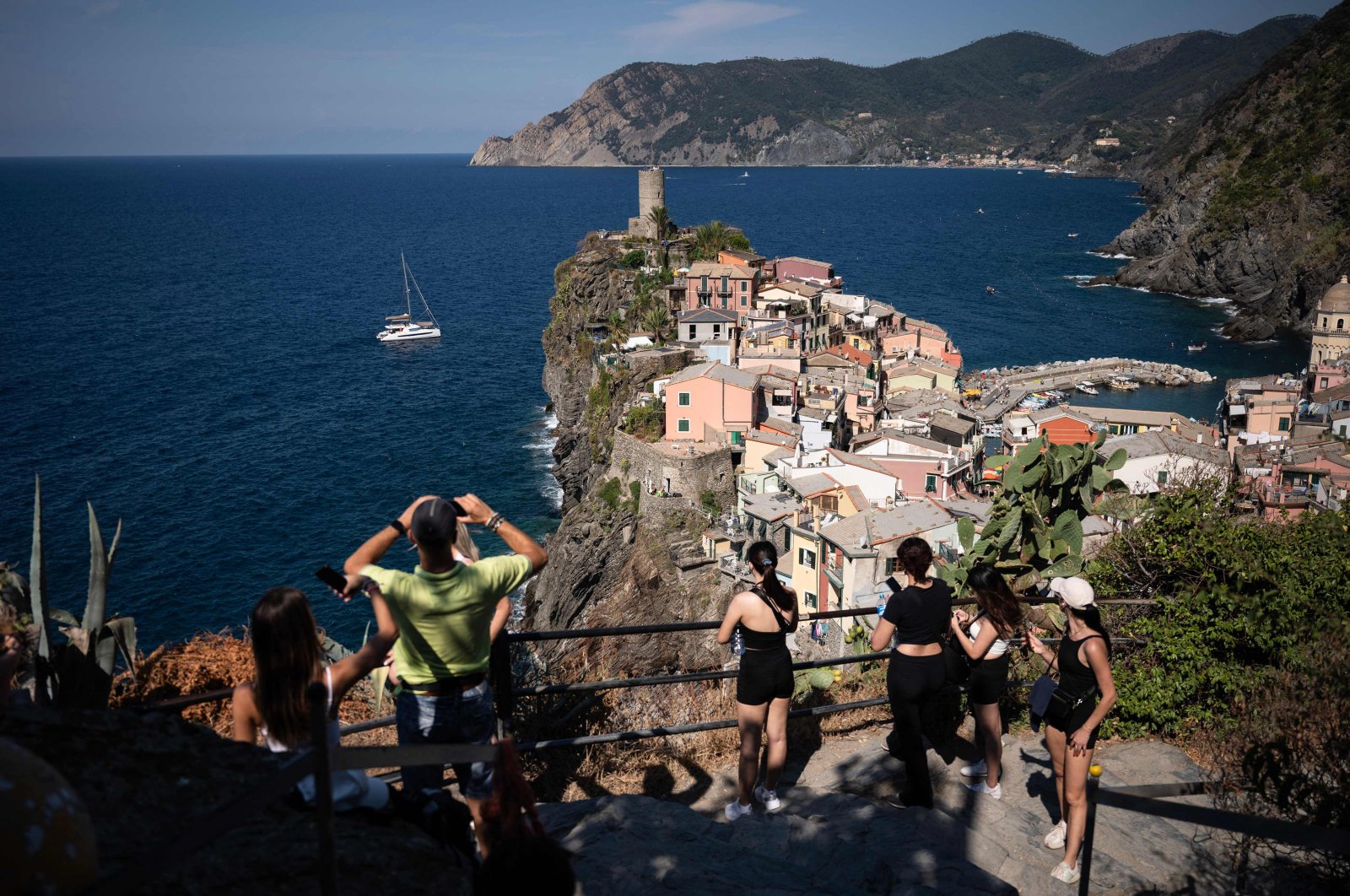 Tourists look out from a hillside in Vernazza in the Cinque Terre National Park, near La Spezia, Italy, Aug. 14, 2024. (AFP Photo)