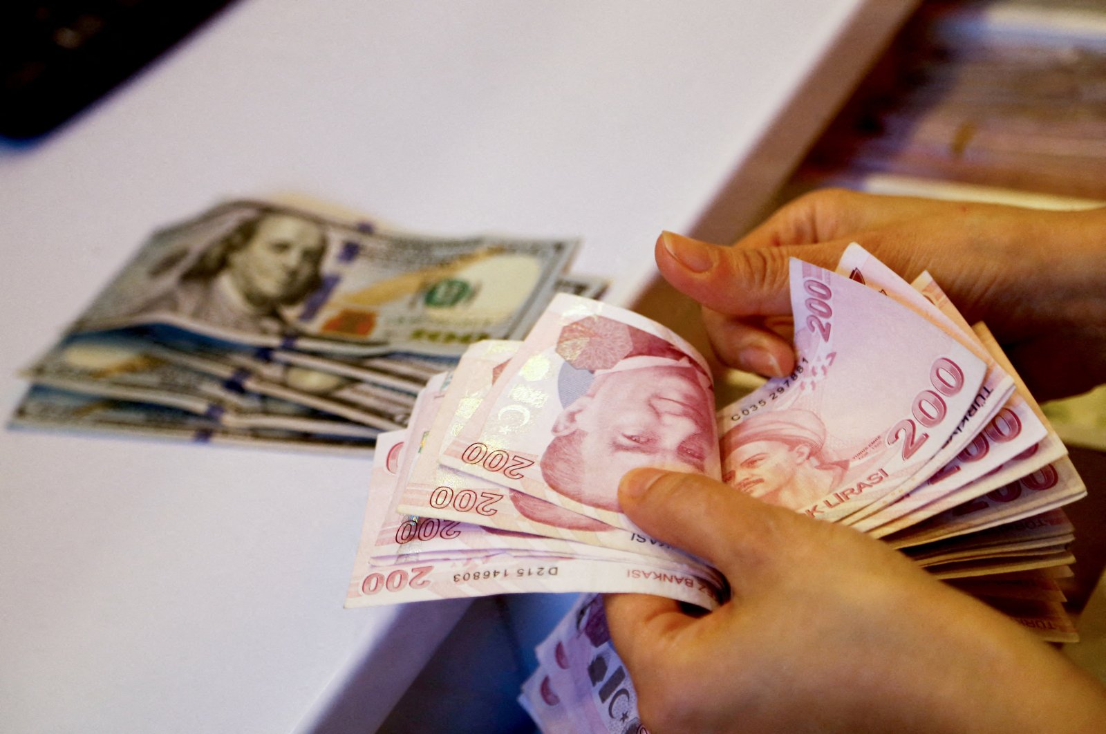 A money exchanger counts Turkish lira banknotes at a currency exchange office, Ankara, Türkiye, Sept. 27, 2021. (Reuters Photo)