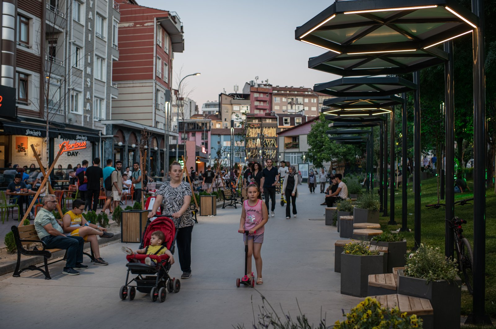 People walk through a cafe and restaurant area in central Kutahya, Türkiye, July 30, 2022. (Getty Images Photo)