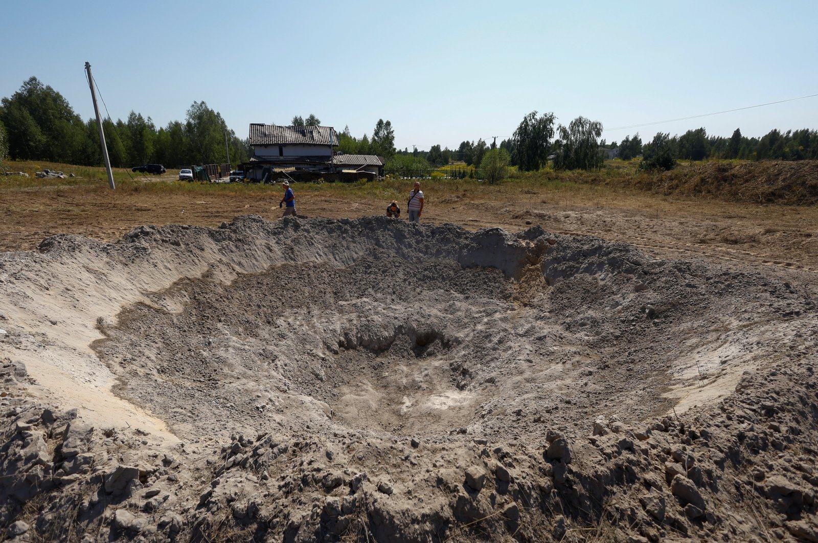 Local residents look at a crater that appeared during a Russian missile strike, amid Russia&#039;s attack on Ukraine, outside of Kyiv, Ukraine, Aug. 18, 2024. (Reuters Photo)